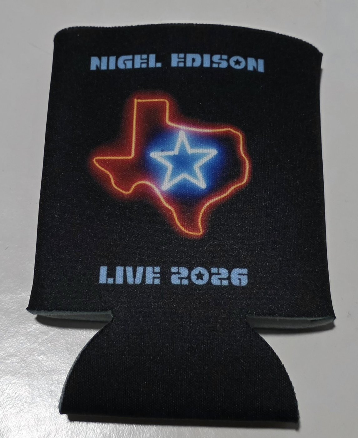 Black Nigel Edison koozie, front: neon Texas outline with a star and LIVE 2026
