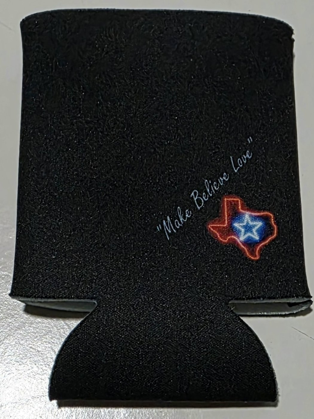 Black Nigel Edison koozie, back: script lettering and a small neon Texas